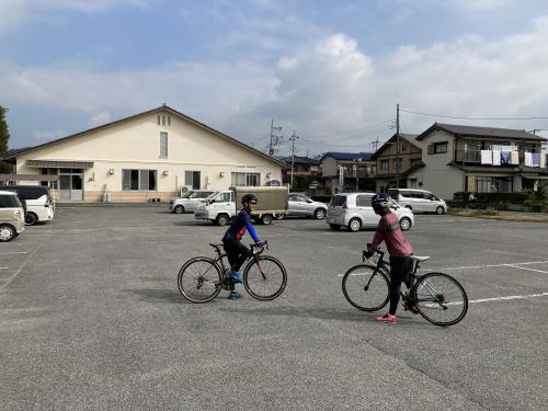 北郷公民館の駐車場からロードバイクで走り出す男女の写真