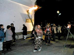鎧行列でかかり火を演出している様子の写真
