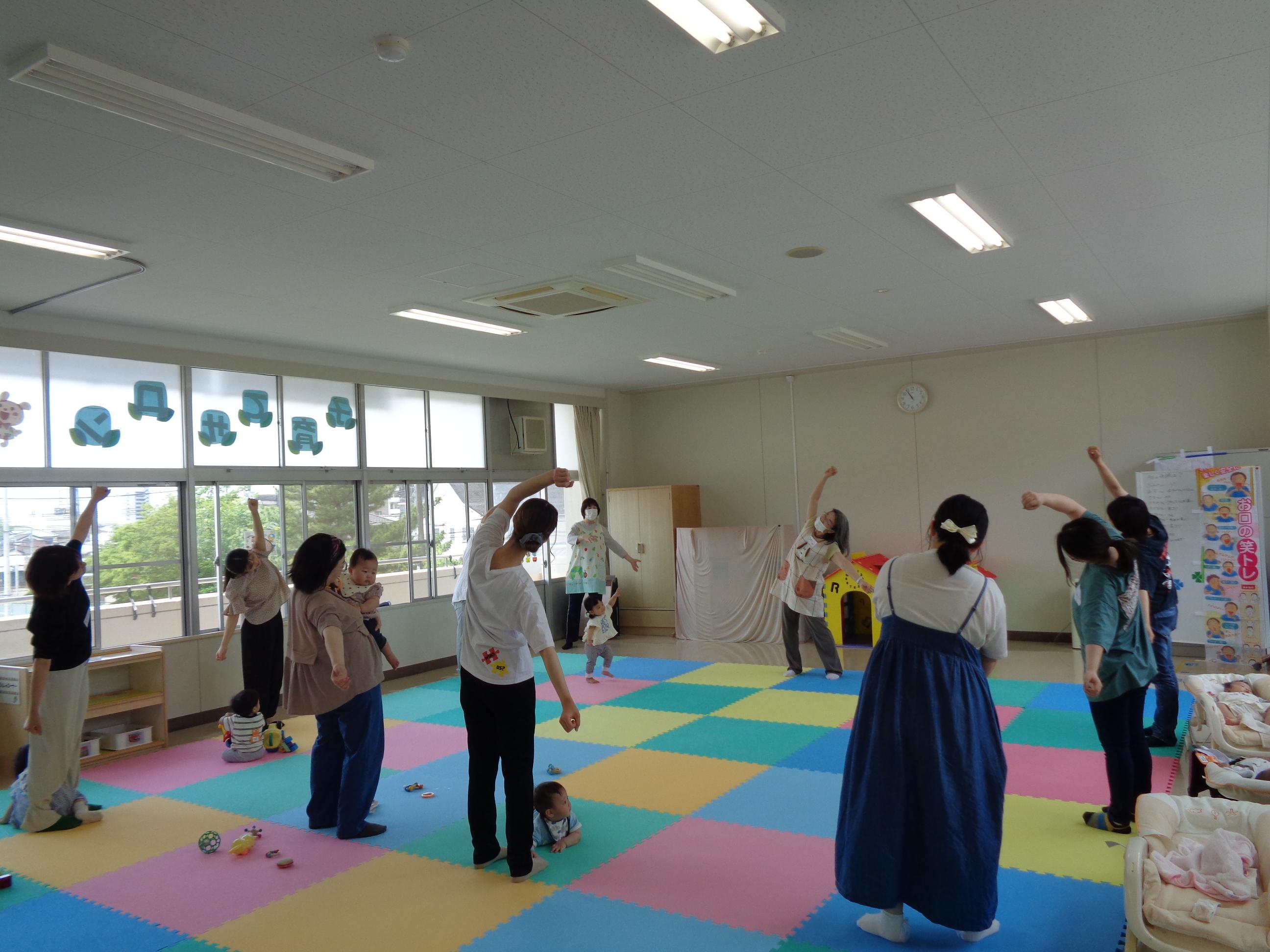 手をあげ笑いヨガを楽しんでいる画像