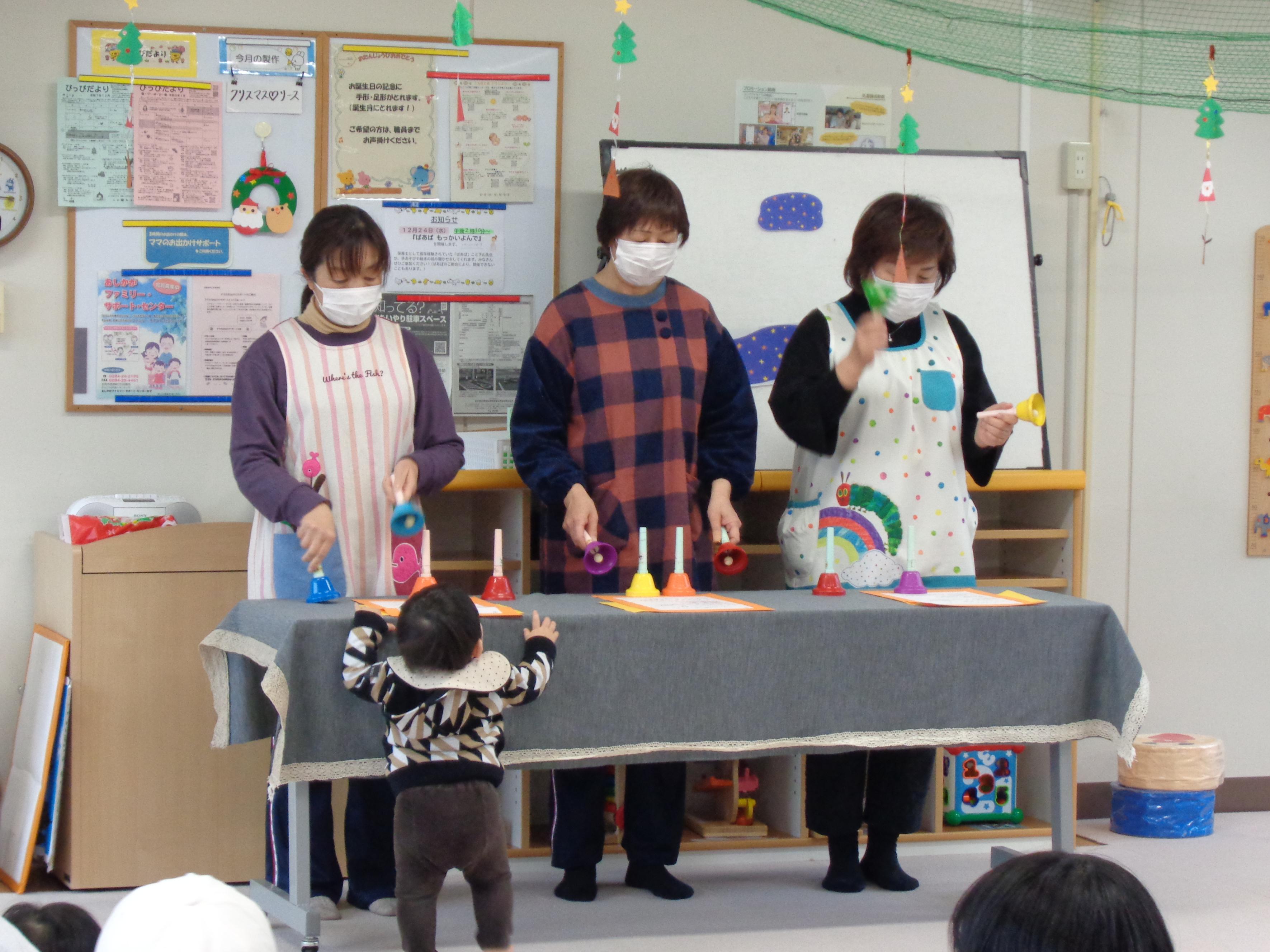 職員3名がクリスマスのハンドベルを演奏している画像