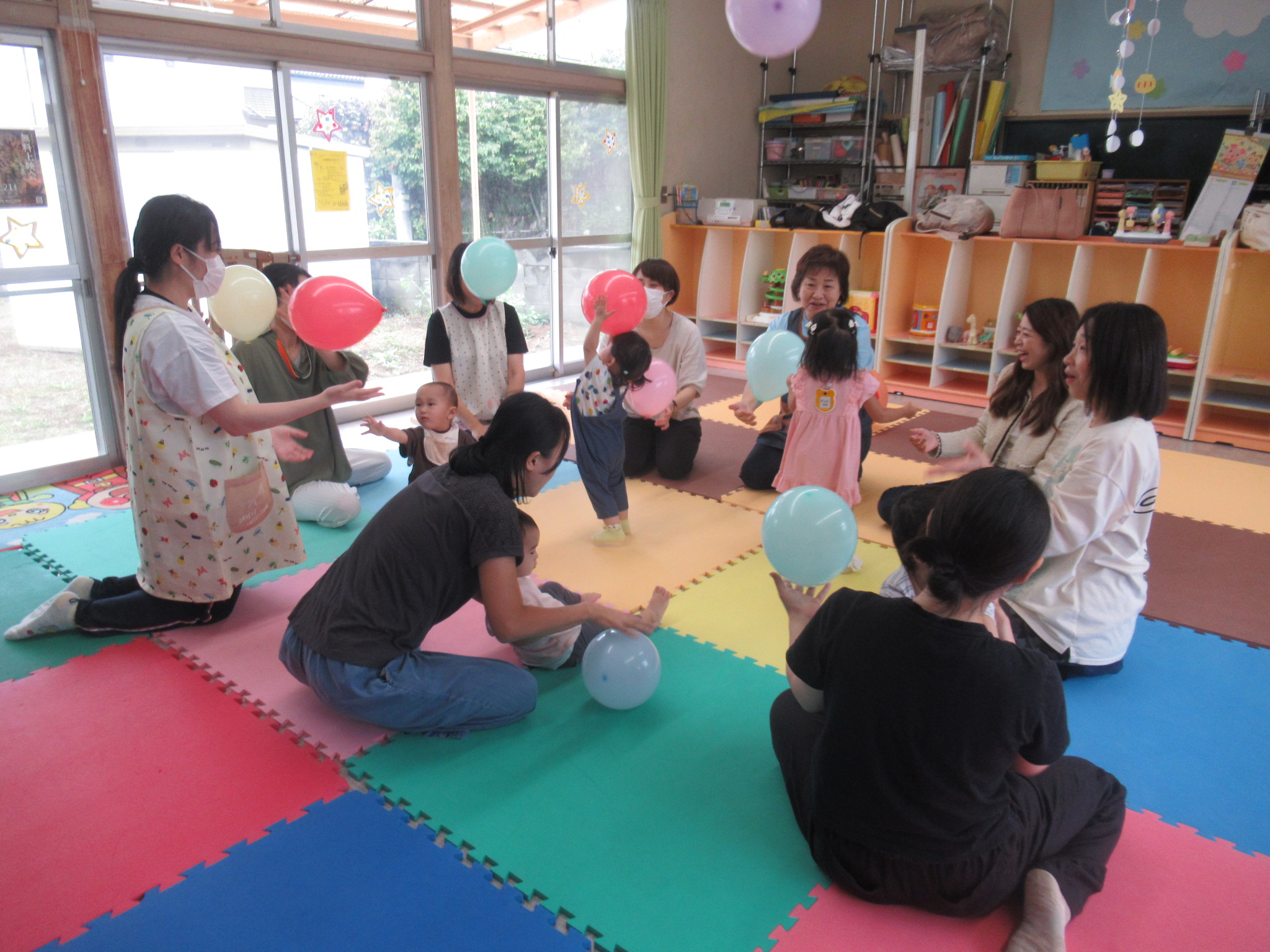 親子で風船で遊んでいる画像です 親子で風船で遊んでいる画像です